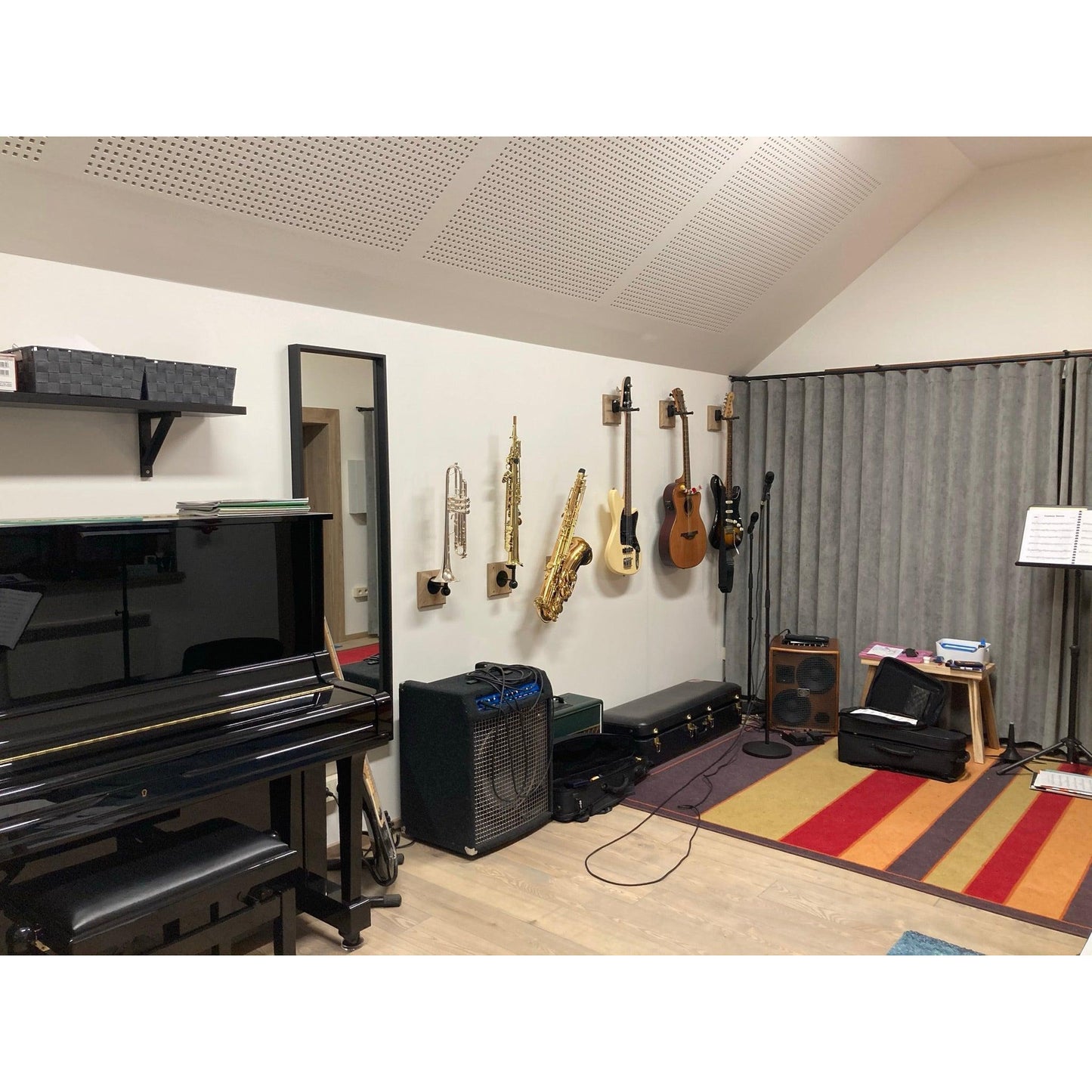 view of studio interior with piano ,many amps and instruments in wall-mounted stands by locoparasaxo