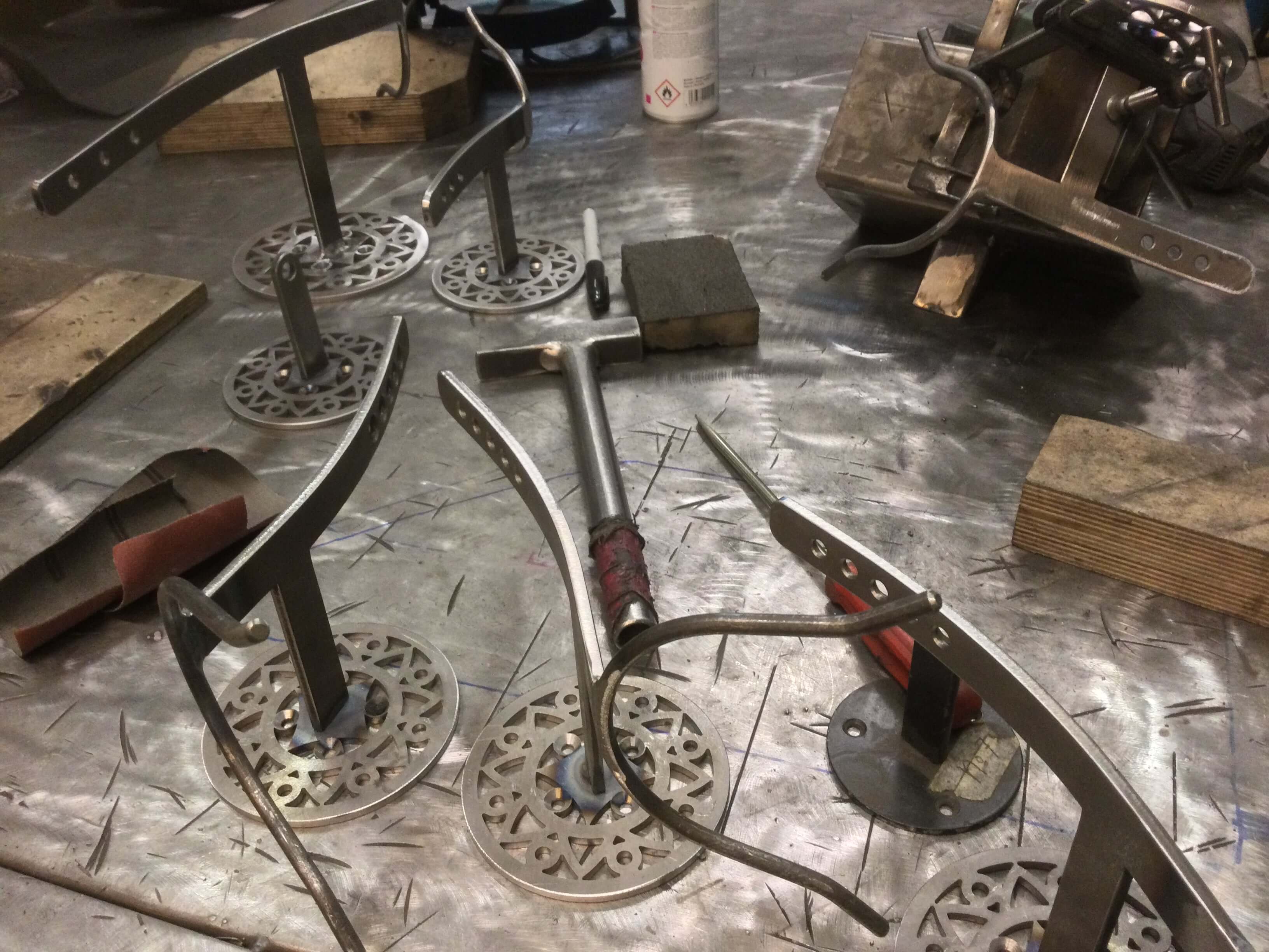 unfinished steel  Aztec saxstands on workbench welding stem to wall plate