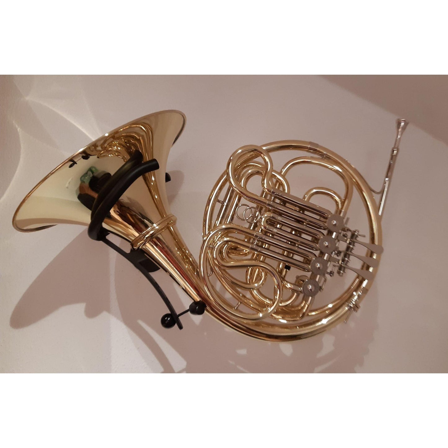 gold colored French Horn in black wallmount Julius by Locoparasaxo
