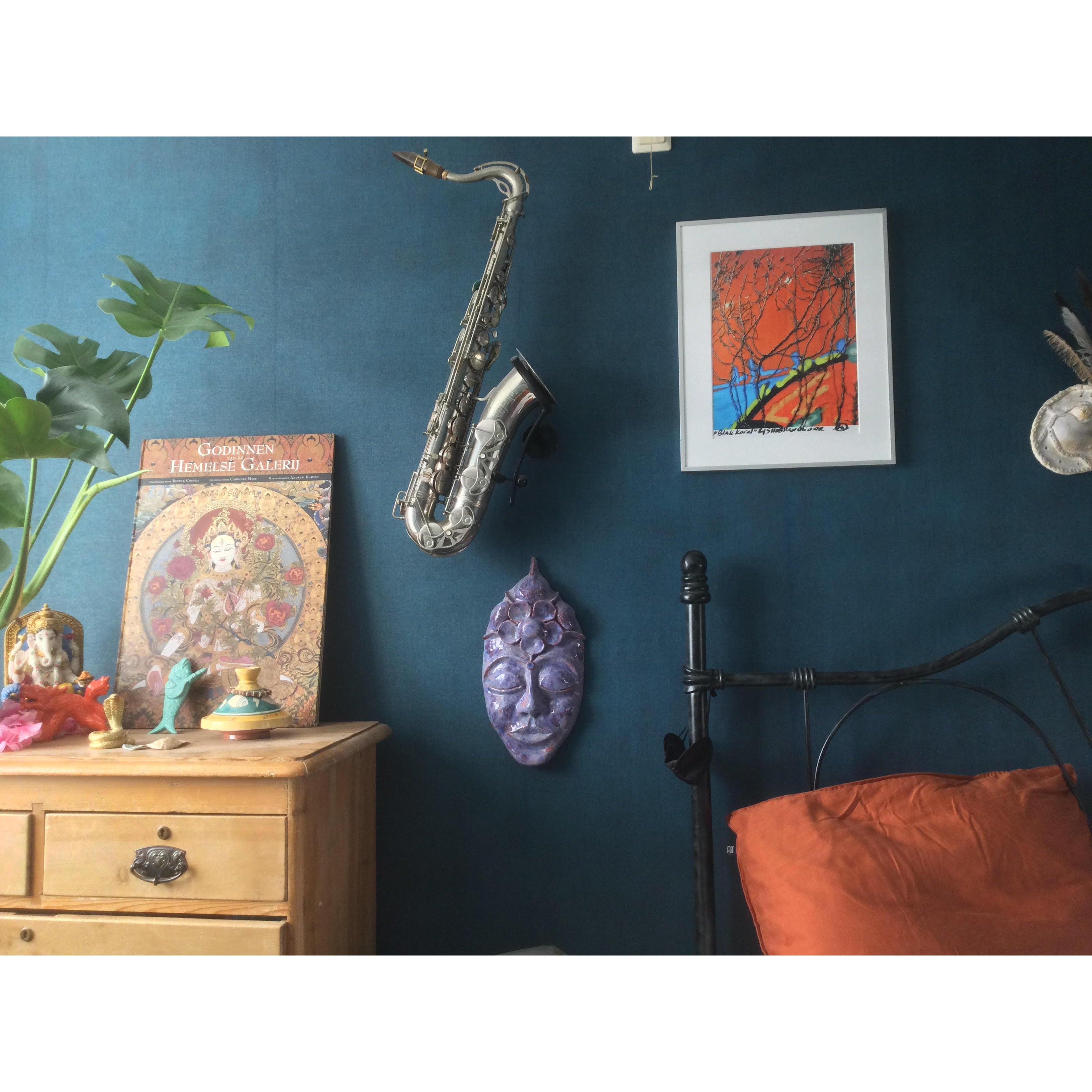 cozy bedroom with tenor saxophone in Locoparasaxo wallmount and several art pieces