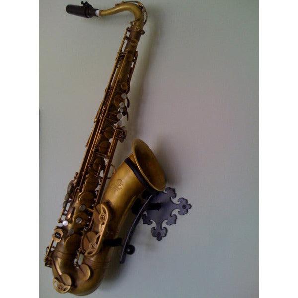 dark brass tenor saxophone on grey backdrop in decorative wallmount made by Locoparasaxo