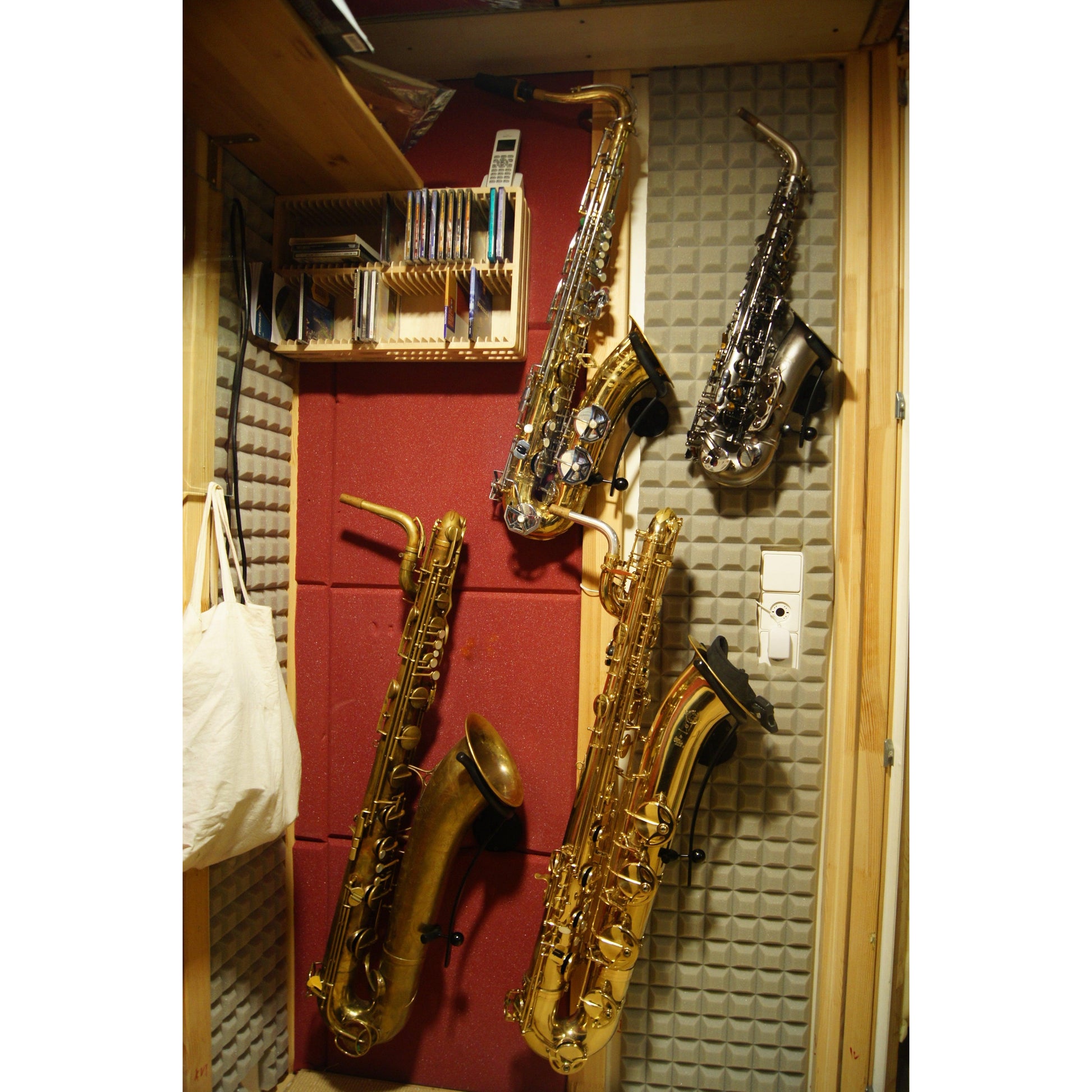 baritone tenor and alto saxophones in Locoparasaxo wall-mounted stands on padded studio wall