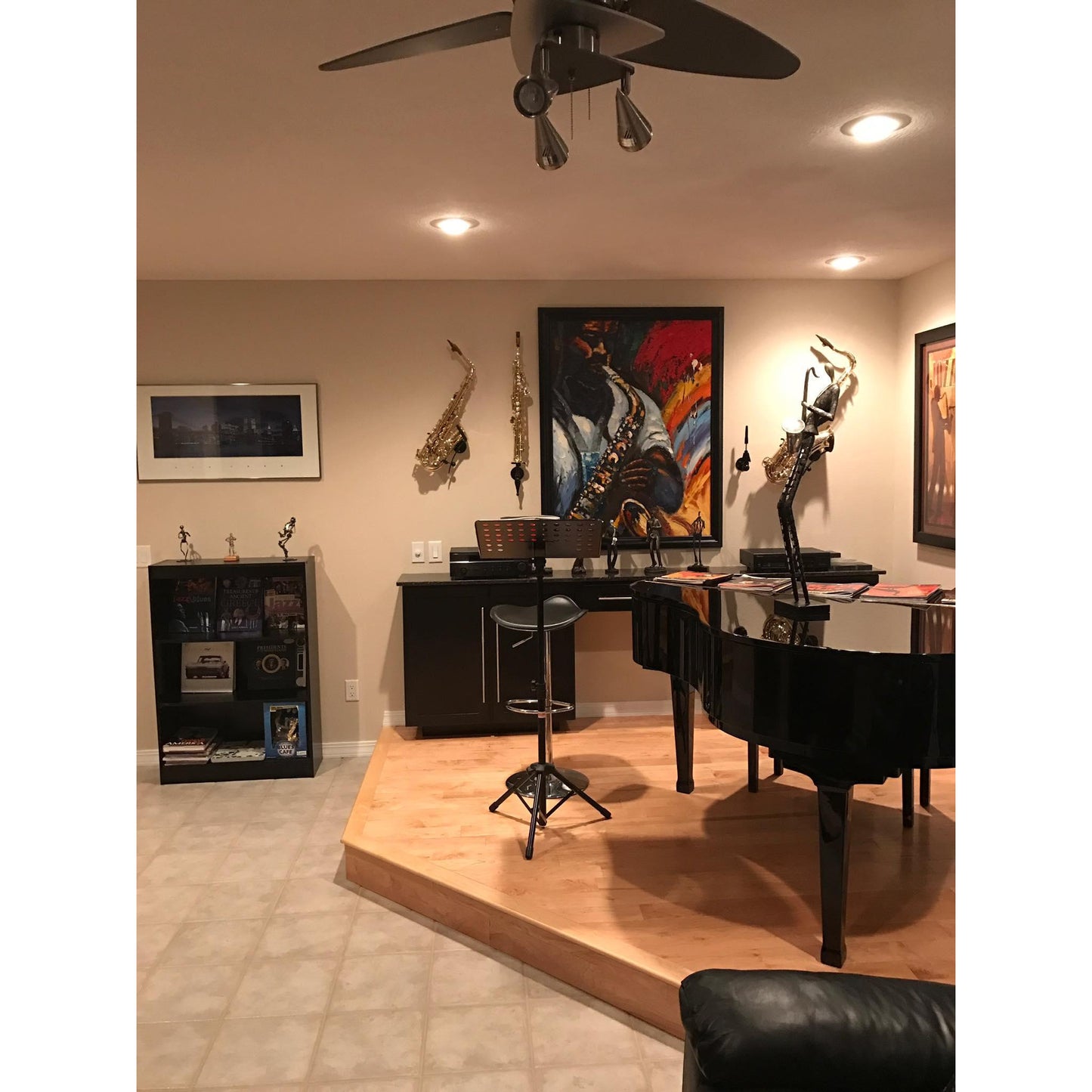 Locoparasaxo customer's luxurious music room or studio with grand piano and several saxophones mounted on the wall beside paintings and art 